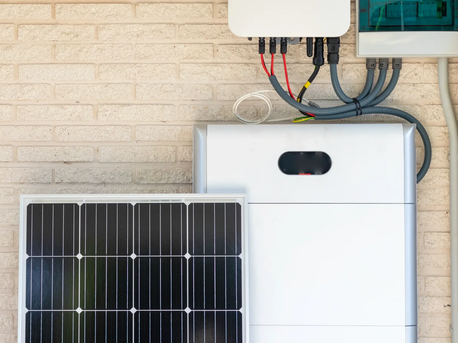 A home battery, inverter and consumer unit mounted on a brick wall